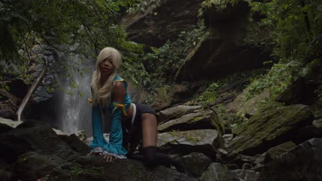 Anime-cosplayer-kneeling-on-a-large-rock-at-the-base-of-a-waterfall-located-on-the-Caribbean-island-of-Trinidad