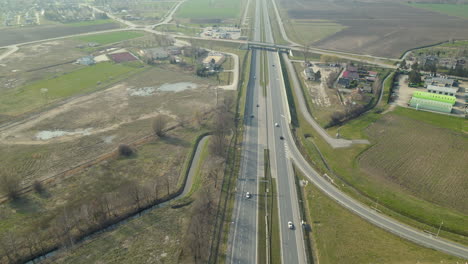 Aerial-backwards-shot-of-driving-cars-on-asphalt-highway-and-bridges-in-Poland