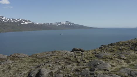 Volando-Más-Allá-De-La-Meseta-De-Roca-Volcánica-Para-Revelar-El-Fiordo-Reyðarfjörður-En-Islandia