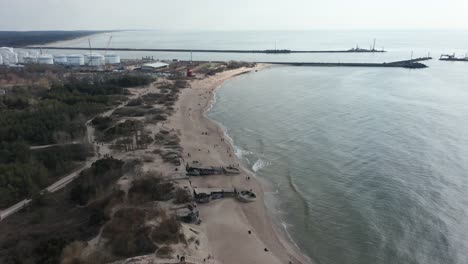 AERIAL:-Sandy-Beach-of-Melnrage-in-Klaipeda-with-Port-Visible-in-Distance