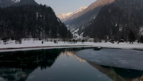 Partially-frozen-lake,-Alpine-mountains-in-background