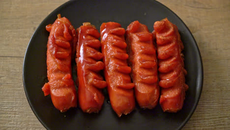 deep-fried-sausage-skewer-on-black-plate