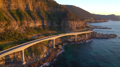 Sonnenuntergang-Auf-Der-Klippenbrücke-Mit-Fahrzeugen,-Die-In-Der-Nähe-Von-Wollongong-Südlich-Von-Sydney,-New-South-Wales,-Australien,-Unterwegs-Sind