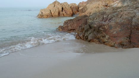 medium-shot-of-beach-and-rocks-with-slow-motion-small-wave