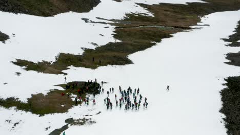Group-of-people-resting-together-during-hike-on-snowy-slope-in-Iceland