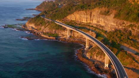 Rocky-Shoreline-With-Elevated-Coastal-Road-At-Sea-Cliff-Bridge-Along-Grand-Pacific-Drive,-New-South-Wales-In-Australia
