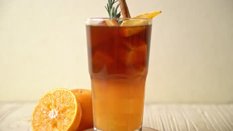 A-glass-of-iced-americano-black-coffee-and-layer-of-orange-and-lemon-juice-decorated-with-rosemary-and-cinnamon