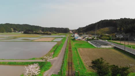 Aerial-tracking-of-straight-train-tracks-running-through-Japanese-countryside