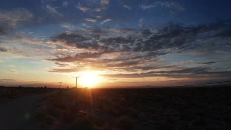 Ein-Herrlicher-Sonnenuntergang-Beleuchtet-Den-Westlichen-Himmel-In-Der-Wüstenlandschaft---Gleitende-Luftaufnahme