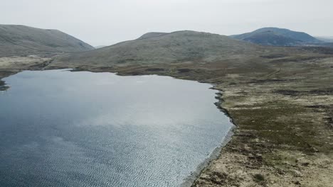 Rotating-and-rising-aerial-view-of-Spelga-Reservoir-and-Mournes