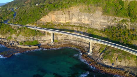 Famous-Sea-Cliff-Bridge-At-The-Grand-Pacific-Drive-With-Cars-Traveling-During-Summer-In-New-South-Wales,-Australia