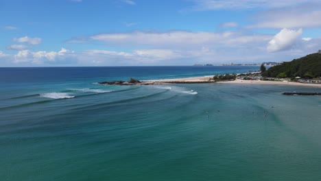 Surfers-Floating-On-Blue-Ocean-Surface-Near-Currumbin-Beach-In-Gold-Coast,-QLD,-Australia