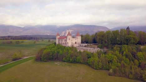 Aerial-panoramic-view-of-Champvent-castle-on-cloudy-day,-Switzerland