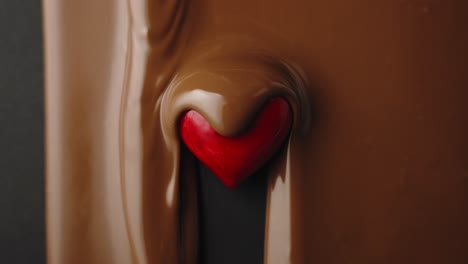 El-Chocolate-Con-Leche-Fluye-Sobre-El-Corazón-Rojo-En-Cámara-Lenta