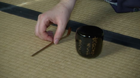 A-bamboo-tea-scoop-and-tea-canister-rest-on-a-tatami-mat-during-a-Japanese-tea-ceremony-