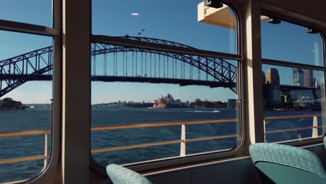 Sydney-Harbour-Bridge-And-Sydney-Opera-House-Seen-From-Window-Of-Ferry-Boat---Through-Arch-Bridge-In-Sydney,-NSW,-Australia