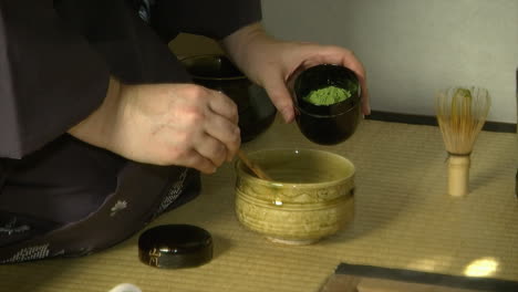 Powdered-matcha-green-tea-is-scooped-into-a-tea-bowl-during-a-Japanese-tea-ceremony-