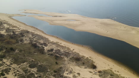 Aerial-shot-of-dry-desert-with-sand-and-natural-lake-in-Nature-Reserve-during-sunny-day