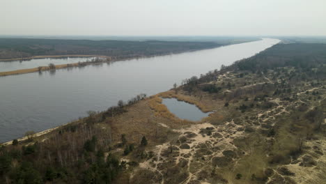 Aerial-shot-over-Vistula-River-and-small-lakes-in-Mewia-Lacha-Nature-Reserve-on-hazy-day