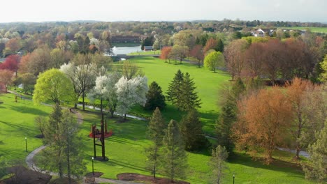 Beautiful-aerial-of-walking-trail,-path-through-park-in-full-bloom-during-spring-season