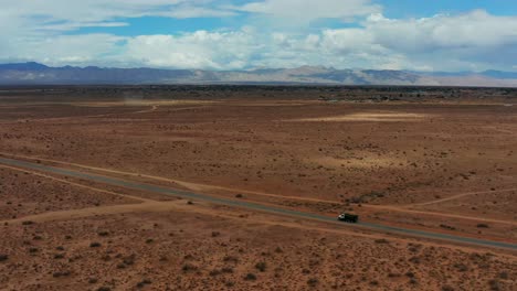 A-lone-truck-drives-through-the-middle-of-the-Mojave-Desert---dynamic-aerial-motion-and-scenic-view