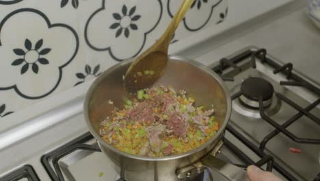 Stirring-minced-meat-and-vegetables-inside-hot-cooking-pot