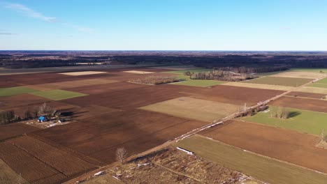 Aerial-wide-angle-of-brown-fields-at-day-with-blue-sky-background