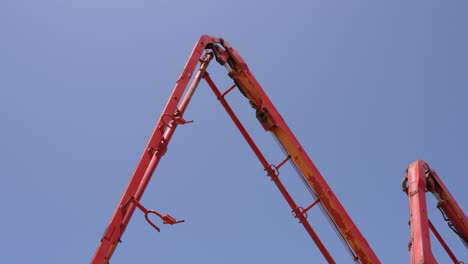 View-of-a-concrete-pump-moving-against-a-clear-blue-sky