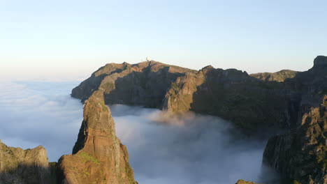 Drone-aerial-footage-of-cloud-inversion-and-mountain-peaks-at-Pico-do-Areeiro-on-the-island-of-Madeira,-Portugal