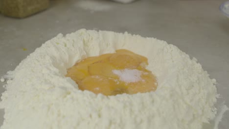 Adding-salt-to-flour-with-egg-yolks-inside