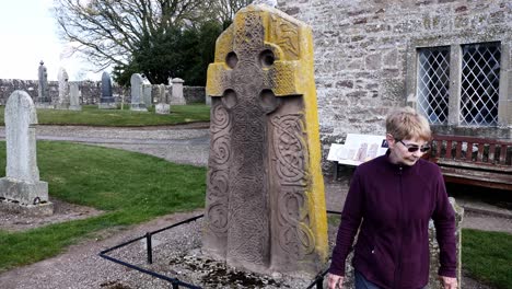 Lady-examines-front-face-of-Pictish-Symbol-stone-in-Aberlemno-Kirkyard