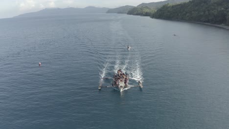 Imágenes-Aéreas-De-Un-Gran-Barco-De-Pesca-En-Marcha-Con-Muchos-Pescadores-Locales-A-Bordo-En-Un-Agua-Azul-Turquesa-En-Una-Isla-Tropical-En-Filipinas