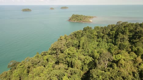 Aerial-fly-over-tropical-jungle-with-ocean-and-tropical-islands-in-distance