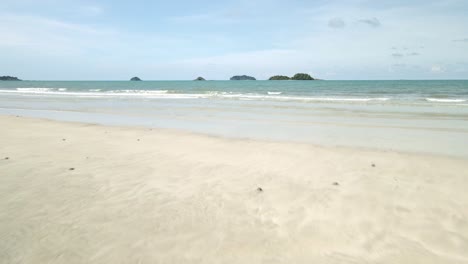Aerial-Drone-Shot-Pull-Out-Low-Gliding-Over-Ocean-Waters-with-White-Sand-on-Koh-Chang-Island-in-Thailand