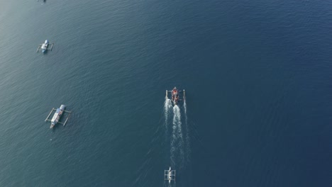 Draufsichtaufnahmen-Von-Kleinen-Und-Großen-Laufenden-Fischerbooten-Auf-Einem-Kristallklaren-Türkisblauen-Wasser-Auf-Einer-Tropischen-Insel-Auf-Den-Philippinen---Luftdrohne