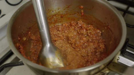 Mashing-meat-ingredients-with-electric-blender-in-metal-pot