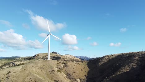 A-static-aerial-shot-of-a-wind-turbine-on-a-hill