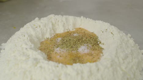 Adding-spice-to-flour-with-egg-yolks-inside