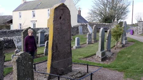 Lady-examines-Pictish-stone-in-Aberlemno-Kirkyard