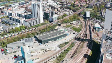 Drone-shot-of-UK-national-rail-intercity-train-leaving-tunnel-arriving-in-London