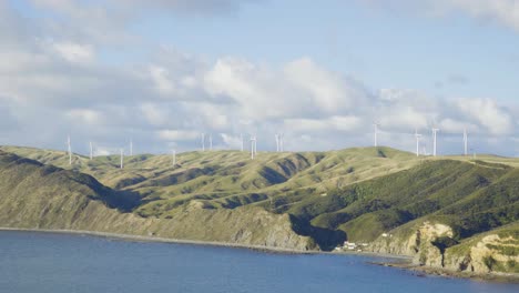 A-coastal-wind-farm-spinning-high-on-a-hill-over-the-water