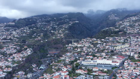 Aerial-drone-footage-of-Funchal-city-with-hills-of-Madeira-in-the-background