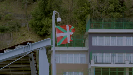 Basque-Country-flag-flys-in-wind-atop-building-in-San-Sebastián,-northern-Spain