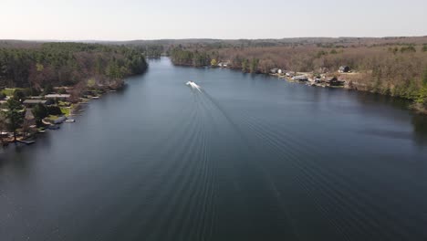 An-aerial-static-view-of-a-watercraft-racing-down-the-middle-of-a-large-lake