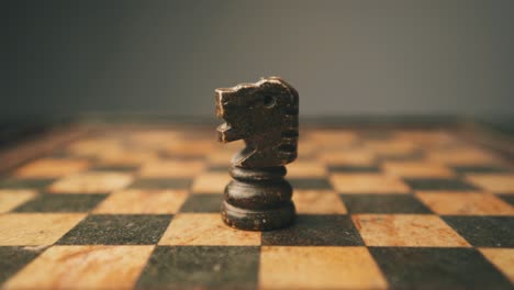 Male-hand-placing-a-black-knight-on-chess-board-close-up-shot