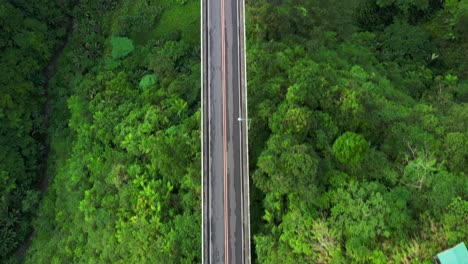 Agas-Agas-Bridge-In-Sogod,-Southern-Leyte,-Philippines---Drone-Flying-Low-Above-The-Concrete-Bridge-Built-On-Lush-Green-Mountains---Aerial-Drone-Vertical-Shot