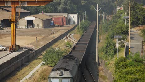 Traditioneller-Chinesischer-Güterzug-Durchquert-Eine-Industriestadt-Im-Tal-Von-Sichuan,-China