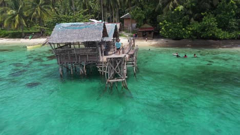 Kid-runs-and-jumps-off-the-water-with-family-in-the-Beach-of-San-Pablo-Island-Philippines,-Aerial-Shot