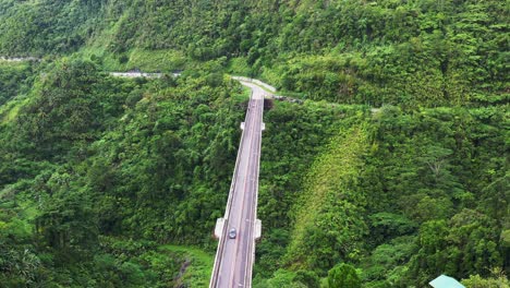 Motorcycle-overtakes-the-car-going-through-the-Agas-Agas-Bridge-in-Sogod,-Southern-Leyte-Philippines,-Aerial
