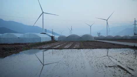 Ein-Großer-Chinesischer-Windpark-Im-Tal-Von-Sichuan,-Zwischen-Traditionellen-Chinesischen-Farmen-Mit-Arbeitenden-Bauern